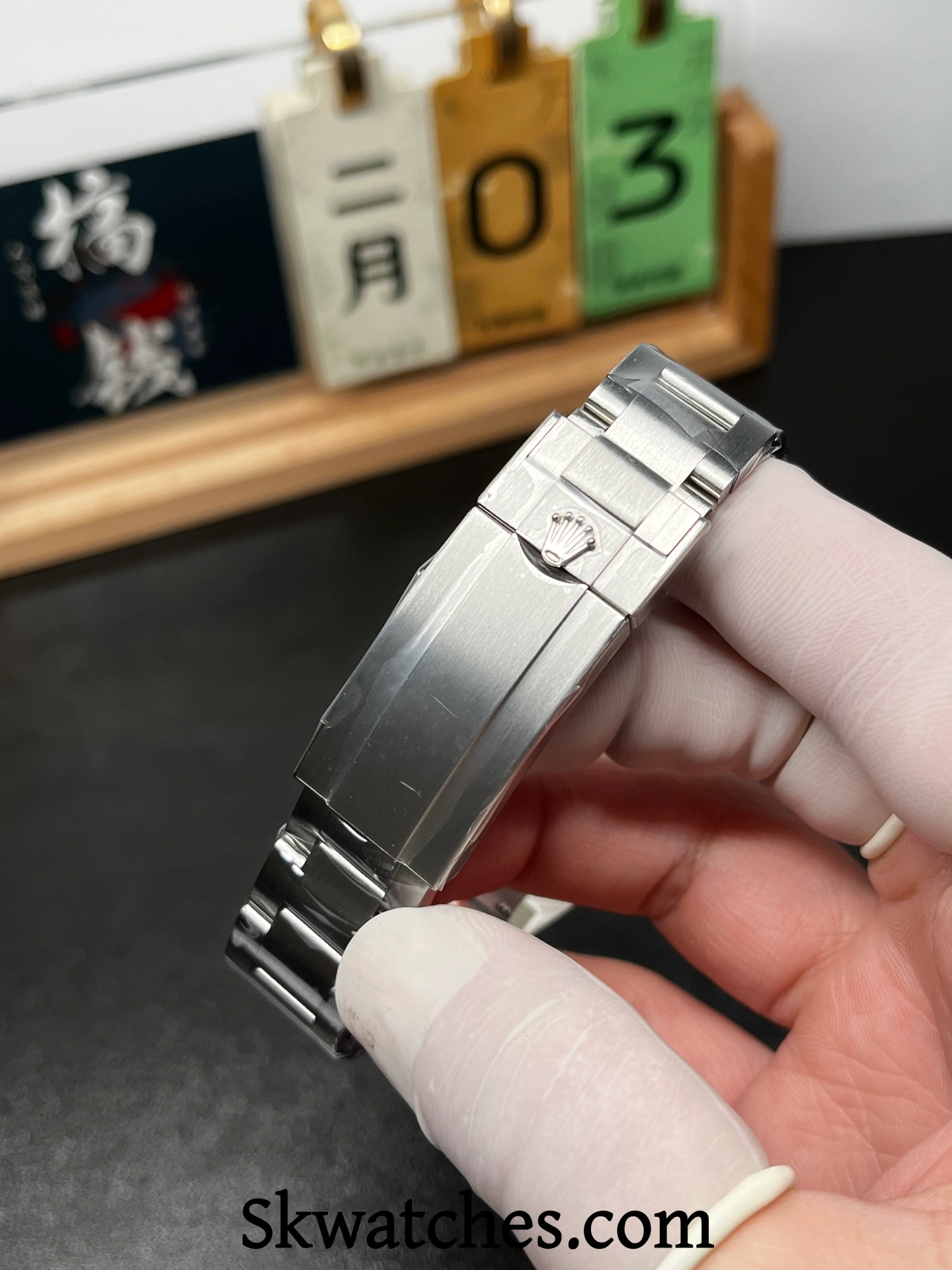 Oyster style clasp detail on a Rolex Submariner replica, showing brushing texture and crown engraving