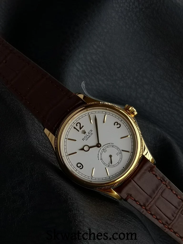 Close-up of ES Factory Replica Rolex 1908 from an angled view, highlighting gold bezel, crown, and dial details