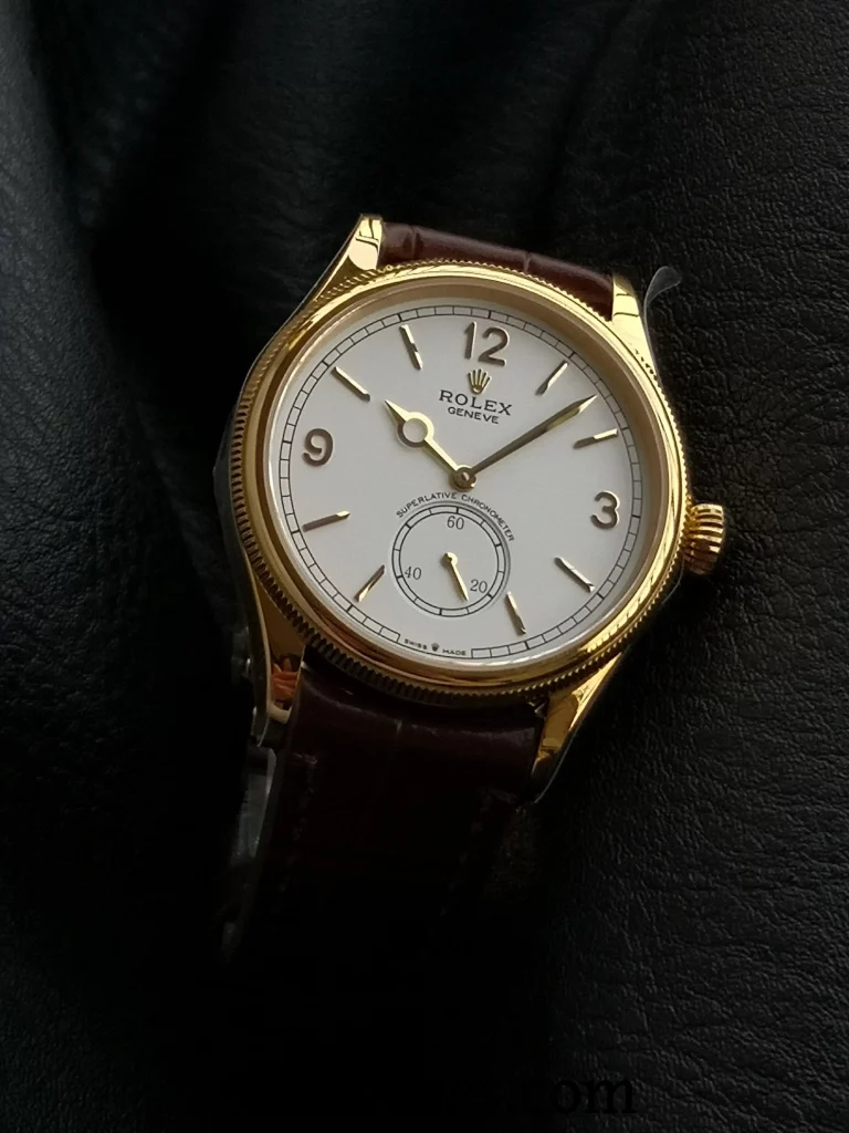Side angle of ES Factory Replica Rolex 1908 showing gold case, white dial, and brown leather strap on a black surface